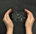 Hands protect children drawn on blackboard with chalk. Concept for International Children`s Day, June 1 Royalty Free Stock Photo