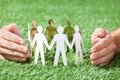 Hands protecting team of paper people Royalty Free Stock Photo