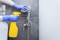 Hands in protective gloves cleaning hygienic shower in sanitary room