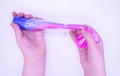 Hands pull out of transparent tube two-tone pink-and-blue slime