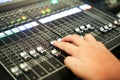 Hands push a Professional audio mixing console with faders and a Royalty Free Stock Photo