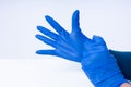 Hands putting on blue nitril gloves Royalty Free Stock Photo