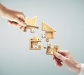 Hands putting puzzle in form house and family