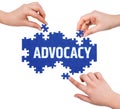 Hands with puzzle making ADVOCACY word Royalty Free Stock Photo