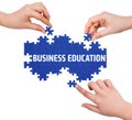 Hands with puzzle making BUSINESS EDUCATION word