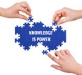 Hands with puzzle making KNOWLEDGE IS POWER word Royalty Free Stock Photo