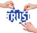 Hands with puzzle making TRUST word Royalty Free Stock Photo