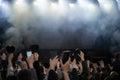 Hands raised up at big open air concert with the crowd background. girl parodies a musical group at a street concert