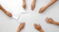 Hands Reaching for Paper on White Surface Royalty Free Stock Photo