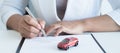 The hands of the real estate agent draw up an agreement, contractual documents on car loans