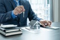 The hands of the real estate agent are holding the keys along with the house insurance contract documents and samples of the house Royalty Free Stock Photo