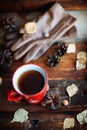 Hands in red knitted gloves holding a hot cup of coffee against yellow leaves background. Concept of autumn time, warmth and cozin Royalty Free Stock Photo