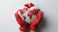 Hands in red knitted mittens holding a heart-shaped globe, conveying love and care for the world