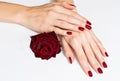 Hands with red manicure and rose