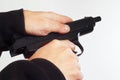 Hands reload semi-automatic handgun on white background