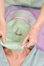 Hands removing alginate facial mask.