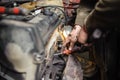 Hands of repairman mechanic working on engine using tool