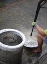 Hands of repairman using Water sprayer clean washing machine