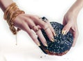 Hands of rich woman with golden manicure and jewelry holding black hamburger closeup fashion concept Royalty Free Stock Photo