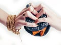 Hands of rich woman with golden manicure and jewelry holding black hamburger closeup fashion concept Royalty Free Stock Photo