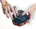 Hands of rich woman with golden manicure and jewelry holding black hamburger closeup fashion concept Royalty Free Stock Photo