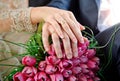 Hands with rings bride and groom on the wedding bouquet of pink Royalty Free Stock Photo