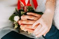 Hands with rings on the fingers of the bride and groom on the background of a wedding bouquet Royalty Free Stock Photo
