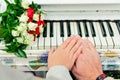 Hands with rings on piano. Beside bouquet of roses Royalty Free Stock Photo