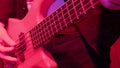 Hands of rock musician playing the electric bass guitar on repetition in red light Royalty Free Stock Photo