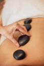 Hands, rock and spa for back massage in relax for healthy wellness, zen or physical therapy treatment at resort. Hand of Royalty Free Stock Photo