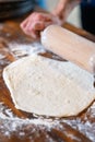 Hands rolling out dough on floured wooden background Royalty Free Stock Photo