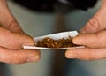 Hands rolling tobacco