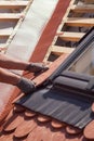 Hands of roofer laying tile on the roof. Installing natural red tile