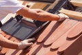 Hands of roofer laying tile on the roof. Installing natural red tile