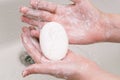 Hands rubbed with soap. Hand washing to prevent the coronavirus pandemic. A piece of soap in the palms close-up Royalty Free Stock Photo