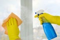 Hands in a rubber protective glove wash the windows with detergent. Cleaning service