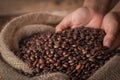 Hands on a sack of coffee beans