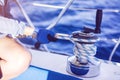 Hands of woman sailor winding rope on sailing winch