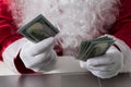 Hands of Santa Claus holding money, dollars. Counting paper currency, payment, shopping concept