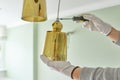 Hands with screwdriver fitting installing lamp, chandelier, closeup Royalty Free Stock Photo