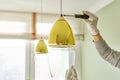 Hands with screwdriver fitting installing lamp, chandelier, closeup Royalty Free Stock Photo