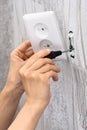 Hands with screwdriver installing a wall power socket