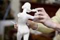 Hands of sculptor works with statuette. Royalty Free Stock Photo