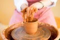 Hands sculpts cup from clay pot. Workshop of modeling on potter wheel Royalty Free Stock Photo