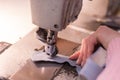 Hands of seamstress, fabric and sewing machine, close-up Royalty Free Stock Photo