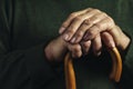 Hands of a senior man clasping a cane