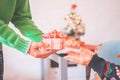 Hands of senior man giving surprise christmas gift box to his old wife. Loving old heterosexual couple celebrating christmas Royalty Free Stock Photo