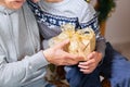 Hands of senior woman and a child holding Christmas gift Royalty Free Stock Photo