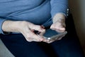 hands of an senior woman holding an smartphone in hands. Closeup, elderly man uses smartphone, touches screen of mobile phone with