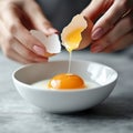 Hands separating fresh egg yolk from white over white bowl in modern kitchen. Generative AI Royalty Free Stock Photo